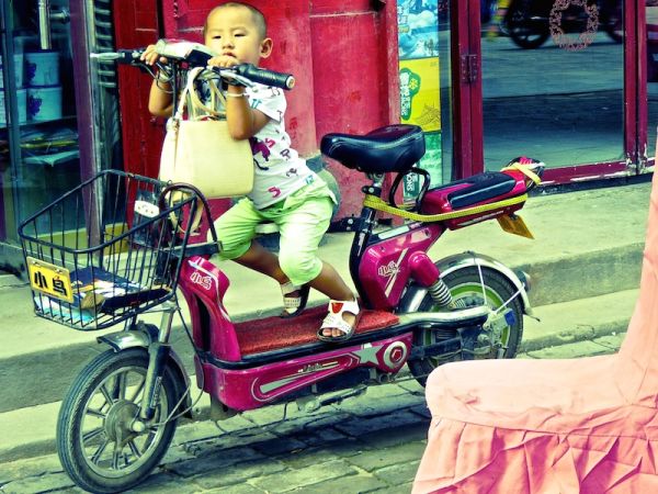 Scène de rue à Pingyao Scène de rue dans la vieille ville de Pingyao : un enfant sur son scooter