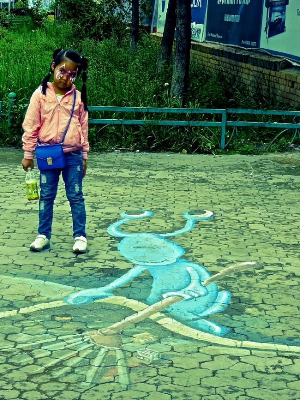 Little girl posing on a 3D pavement graffiti in Ulan Bator