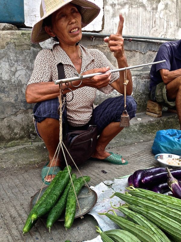 Buying the ingredients at the local market in Yangshuo before the cooking course Measuring vegetables the old fashioned way at the Yangshuo local vegetable market