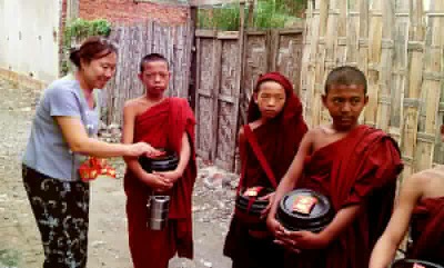 Nan Bwe of Yoe Yoe Lay Guesthouse offering food to the monks Nan Bwe of Yoe Yoe Lay Guesthouse offering food to the monks