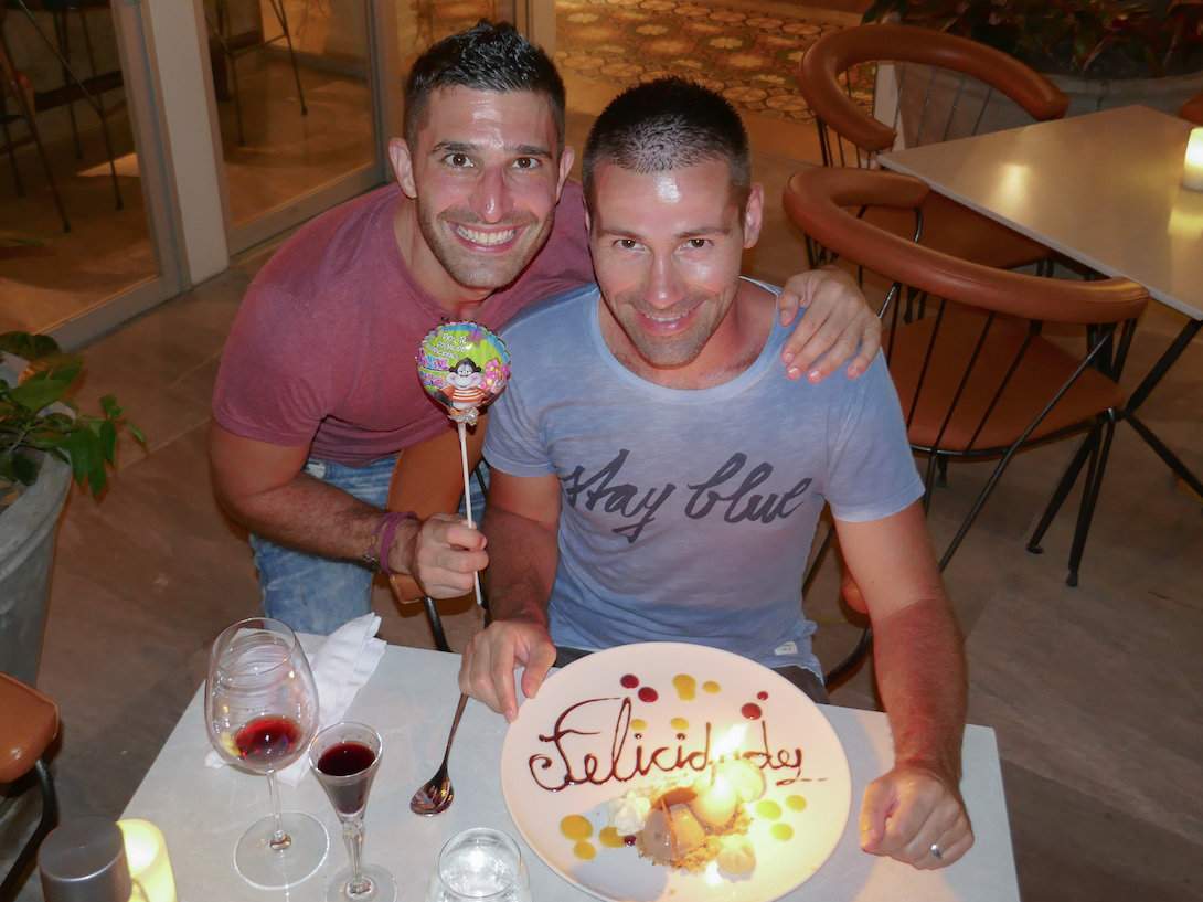 Gay couple at the Carmen gay friendly restaurant in Cartagena with a birthday cake and balloon.