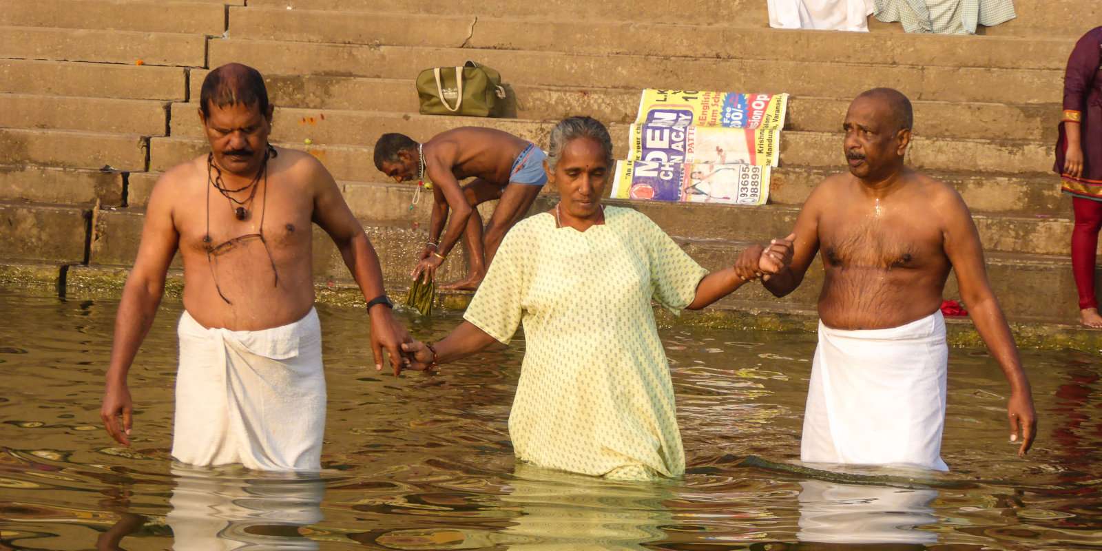 Hindu pilgrims praying and bathing by the ghats of Varanasi