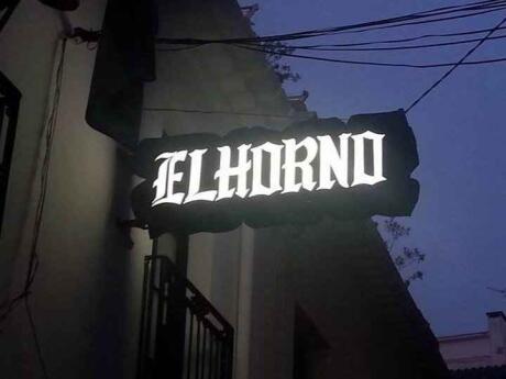 The El Horno illuminated street sign at night.