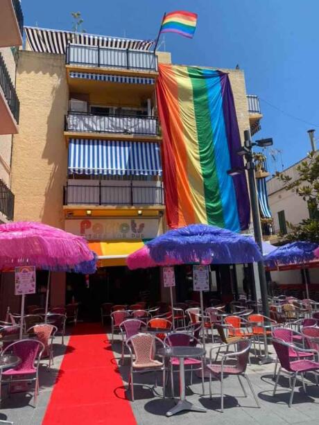 Parrots gay pub in Sitges decked out in rainbow flags on a sunny day.