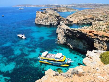 Gay travellers to Malta will have a blast visiting the Blue Lagoon on a catamaran with slides and a bar!