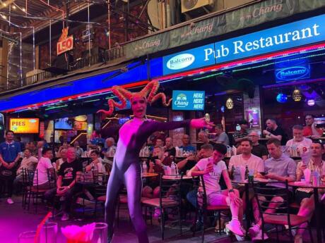 A drag performer on the busy street at Balcony gay bar in Bangkok.