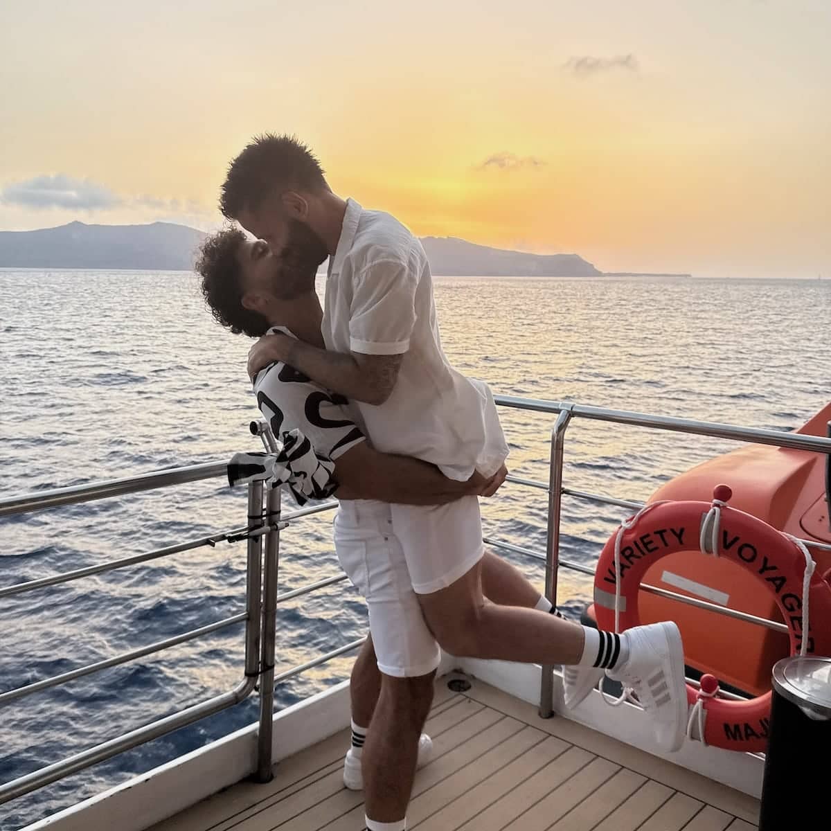 Gay couple kissing at sunset on the Out Adventures gay cruise in Greece.