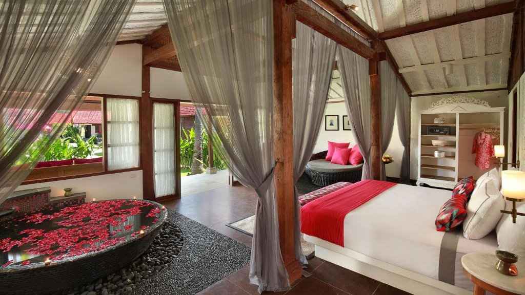 A luxurious bedroom with bathtub at PinkCoco Gili Air.