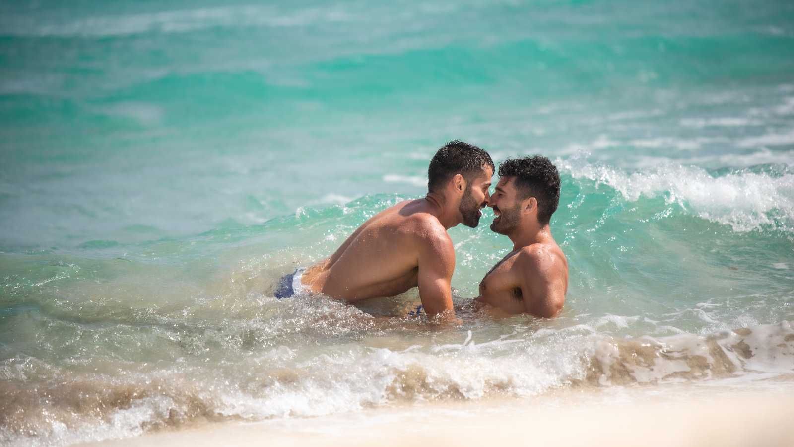 Gay couple on the beach expressing PDAs 