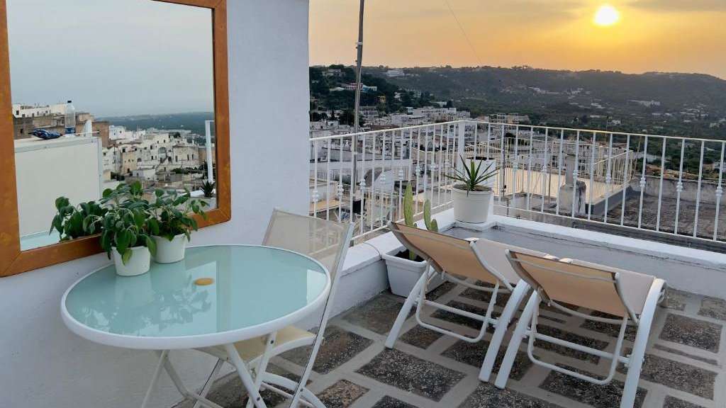 Sunset over Ostuni in Italy as seen from a rooftop balcony. 