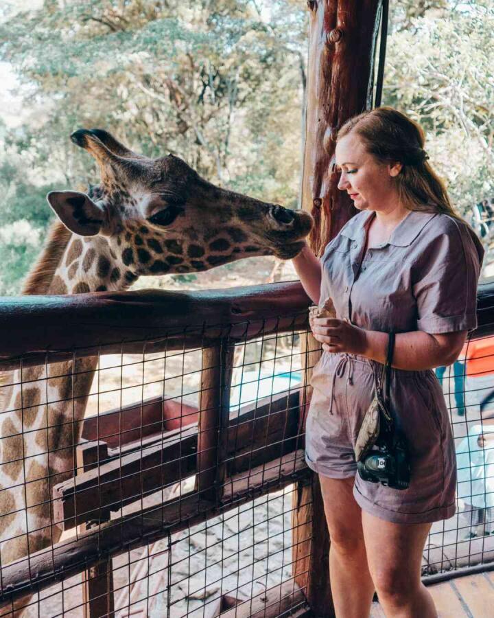 Meg Ten Eyck, famous Lesbian blogger in one of her trips to Africa where she is posing with a giraffe.