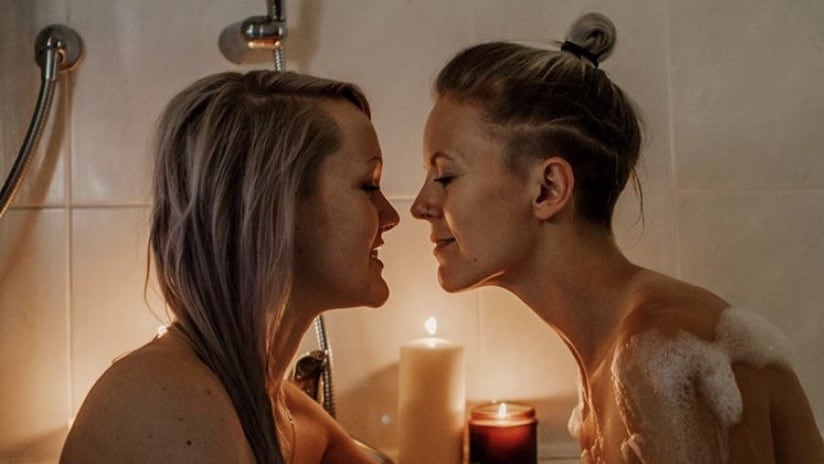 Lesbian couple Our Taste for Life, pictured together having a romantic moment in a bath. 