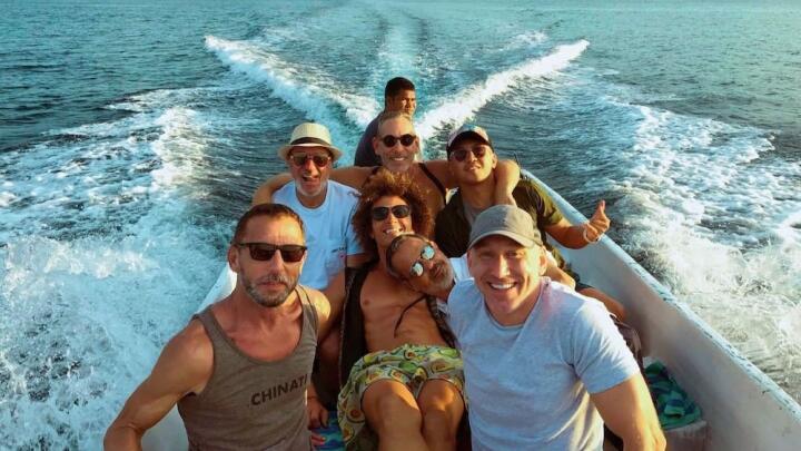 Group of gay men on speedboat.