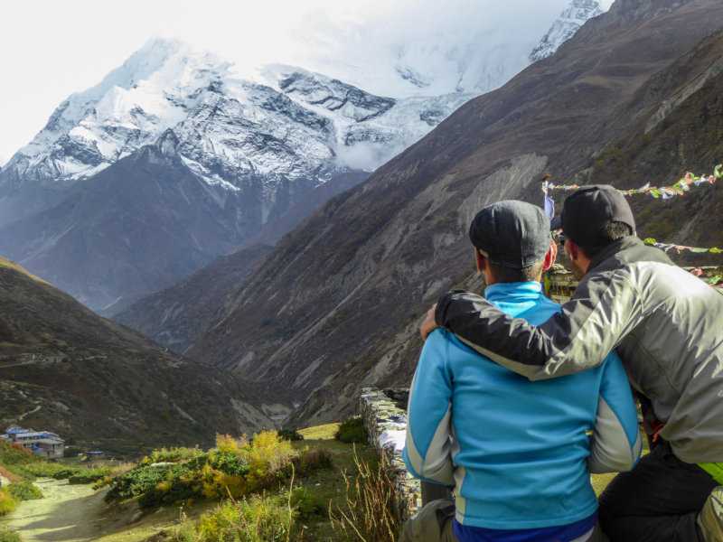 Gay couple enjoying the view of the Himalayas during the Annapurna Circuit in Nepal.
