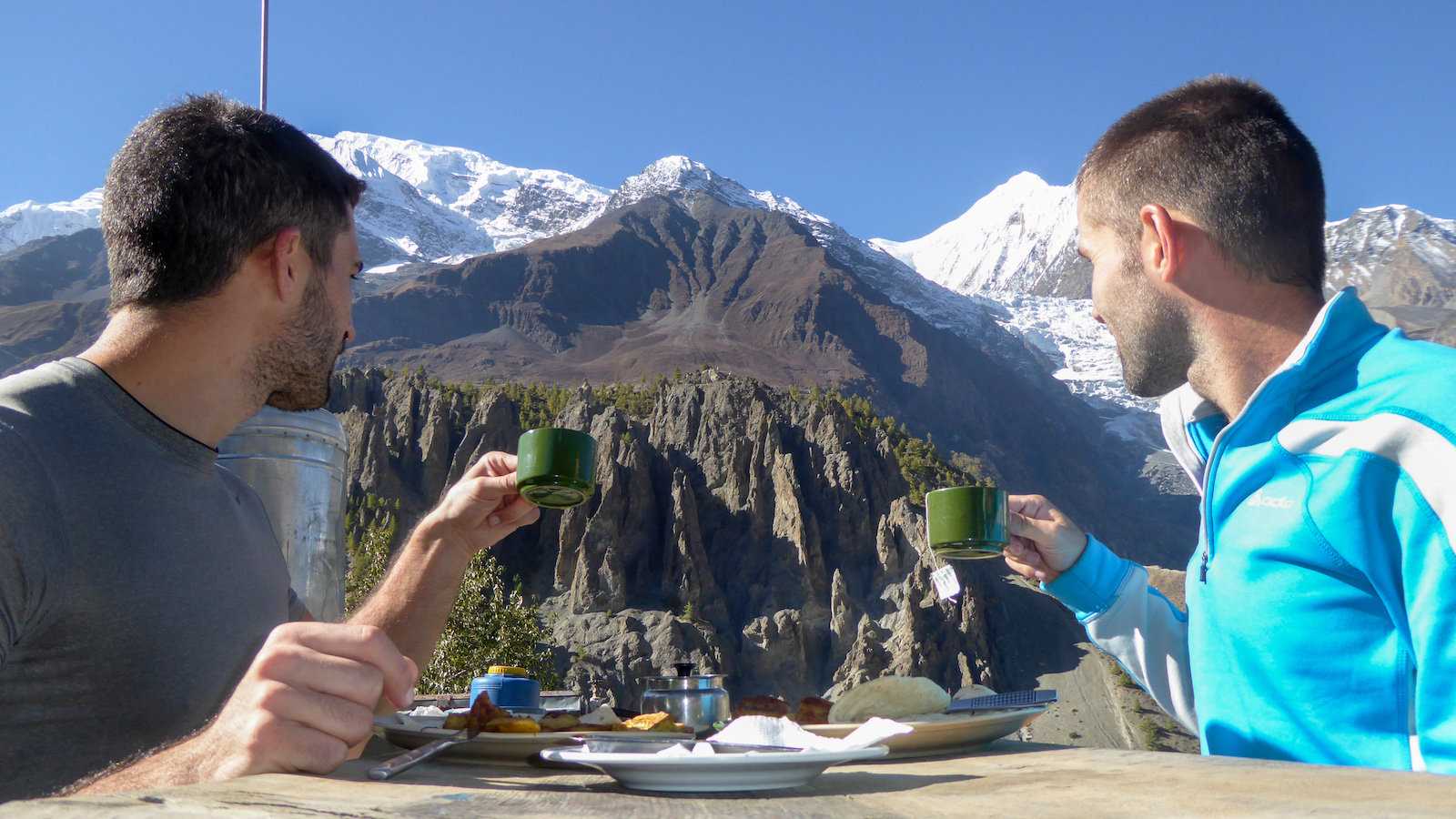 Gay couple enjoying breakfast and morning coffee with the Himalayas background in Nepal.