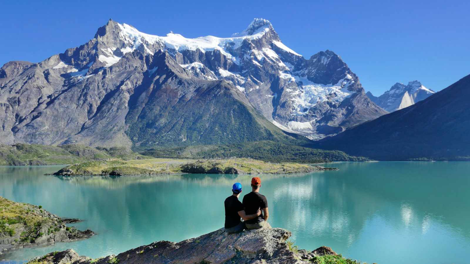 Gay couple trekking in Patagonia watching the mountains in the Torres del Paine National Park in Chile.