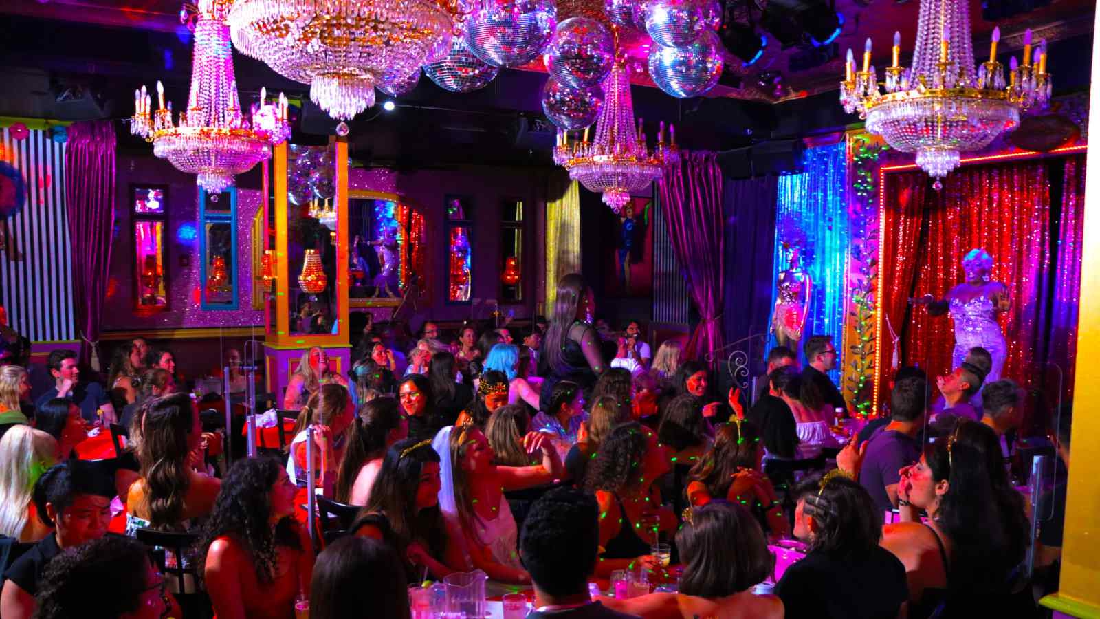 A crowd of patrons enjoying food and drag performances at Lips drag dining in New York City.