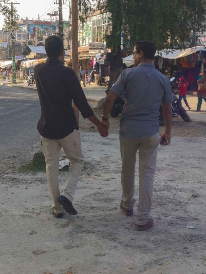Men holding hands walking in the streets in Kathmandu in Nepal.