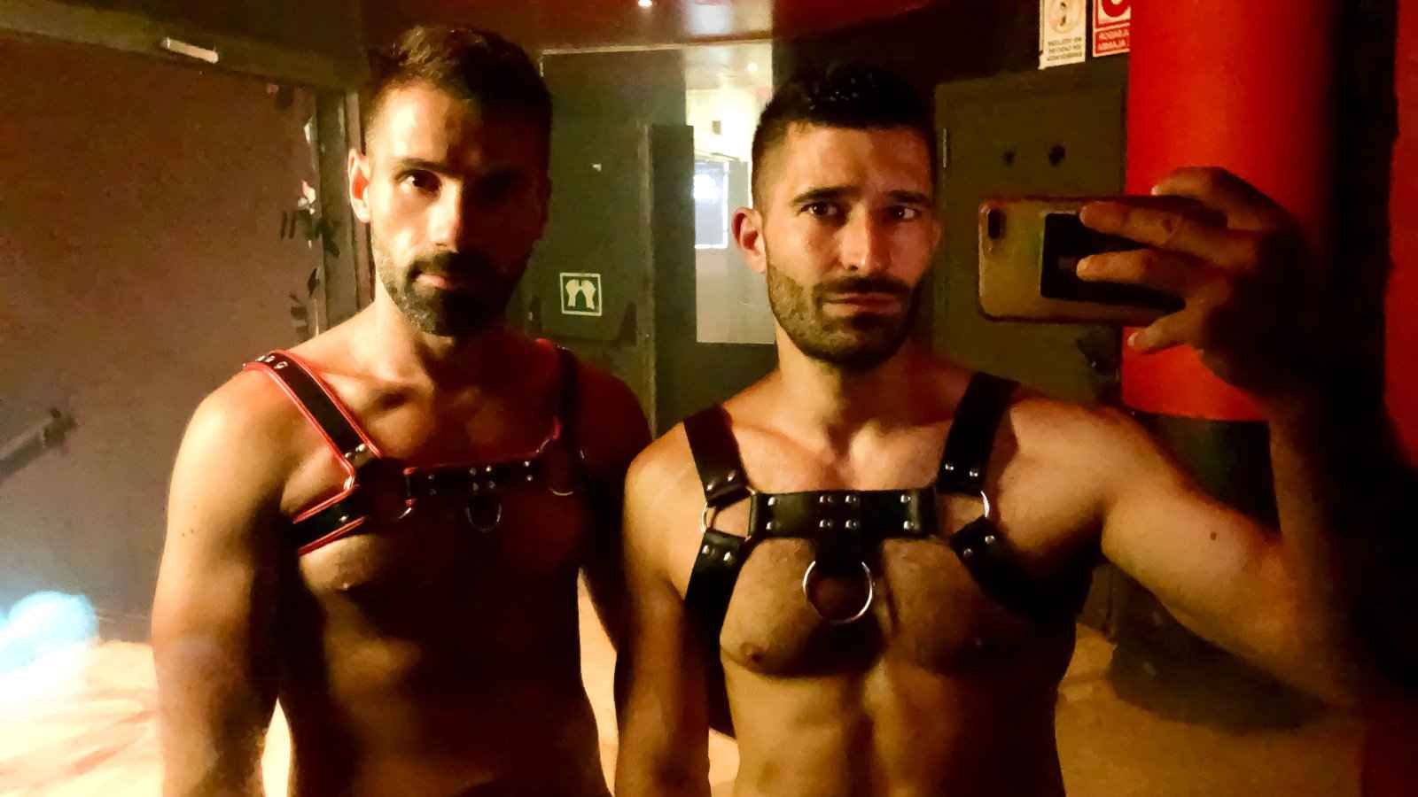 Two hot men taking a selfie with harnesses in london week.