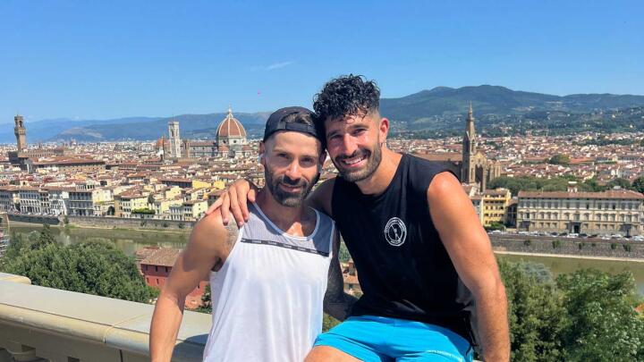 Seby and Stefan at a viewpoint with the city of Florence behind them on a sunny day.