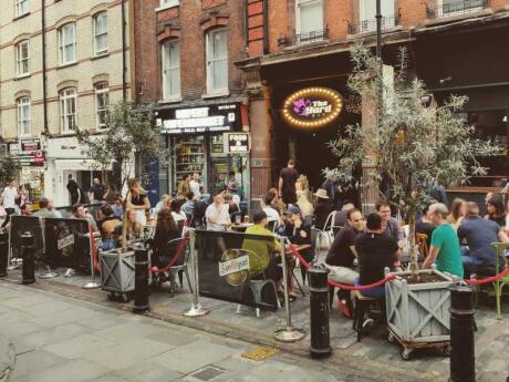 Crown sitting at the front of The Yard Bar, one of the best gay bars in London with outdoor seating.