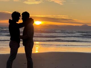 Gay couple on beach at sunset