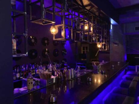 View of the bar in black and purple with soft lighting from Nu House of Music.