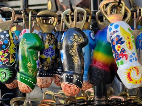 A variety of colorful penis-shaped bottle openers at a stall.