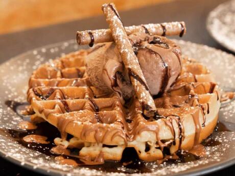 A plate of waffles with chocolate ice-cream and sauce from Rooster gay friendly Cafe in Athens.