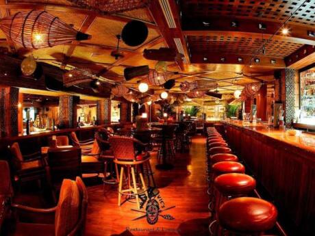 A warm wooden bar with lots of wicker furnishings from Trader Vic Amman.