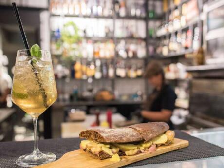 A sandwich and glass of wine sitting on the bar at Bono Bottega Nostrana restaurant in Rome.