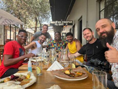 Nomadic Boys sitting at an outside table with a group of friends (and food) at the James XVI Ethiopian Cafe in Johannesburg.