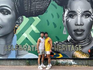 Seby and Stefan of Nomadic Boys standing in front of a mural of two beautiful African women in Johannesburg.