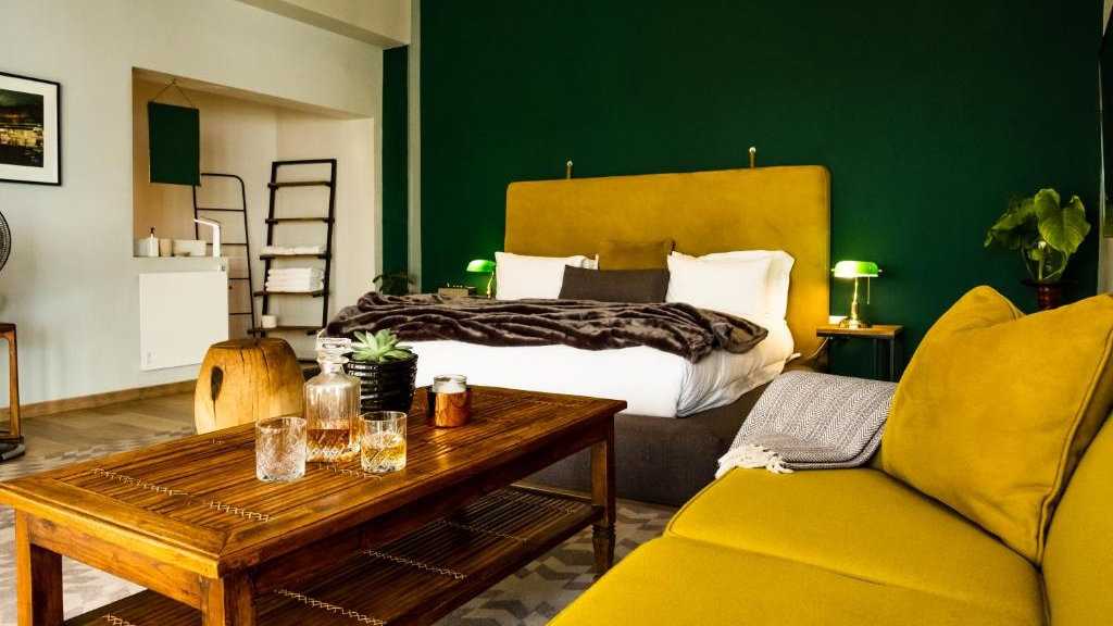 A striking bedroom with accents of green and mustard at the gay friendly Pablo House hotel in Johannesburg.