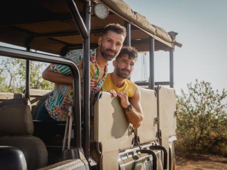 Nomadic Boys leaning out of their jeep during a safari near Johannesburg.