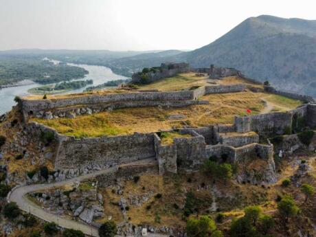 A ruined fortress on top of a green hill from above in Berat in Albania.