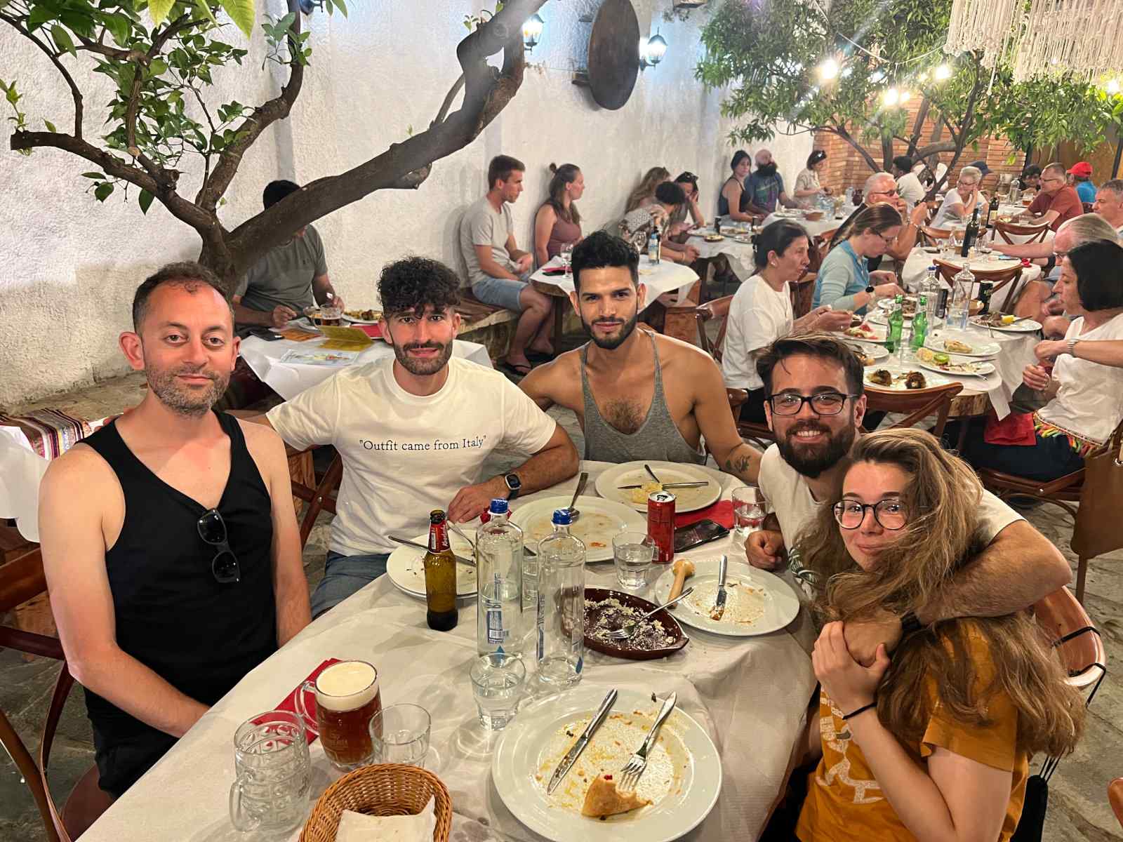 Stefan with a group of gay friends at a table in a busy restaurant in Albania