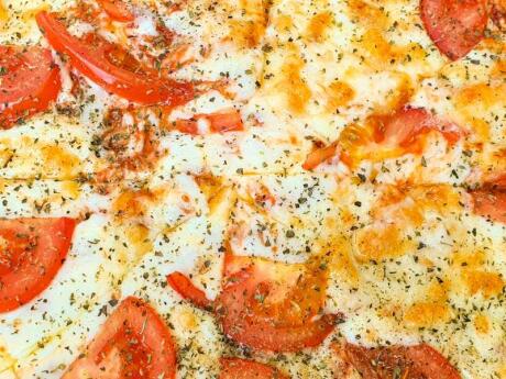 A close up of Albanian cheese baked with tomatoes.