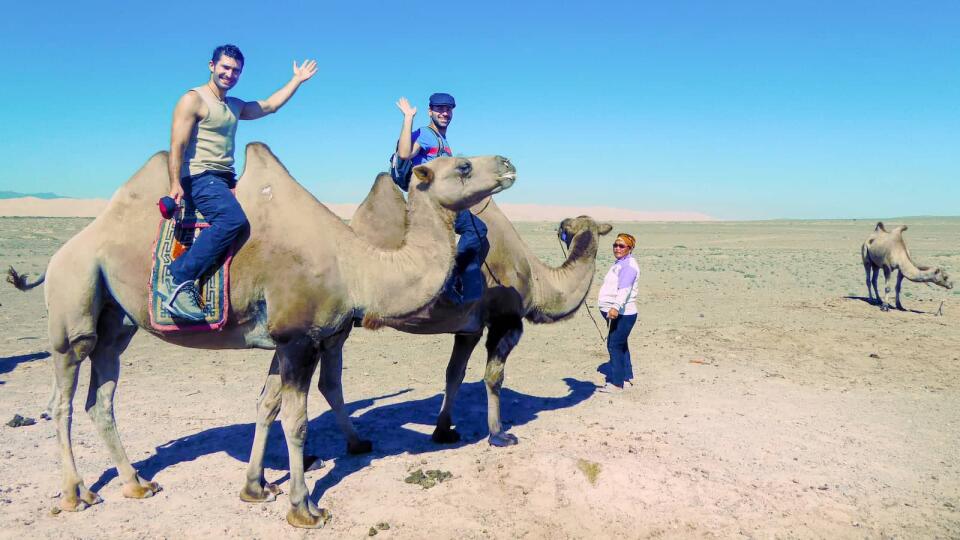 Stef and Seby on camels traveling through the Mongolian Gobi Desert.