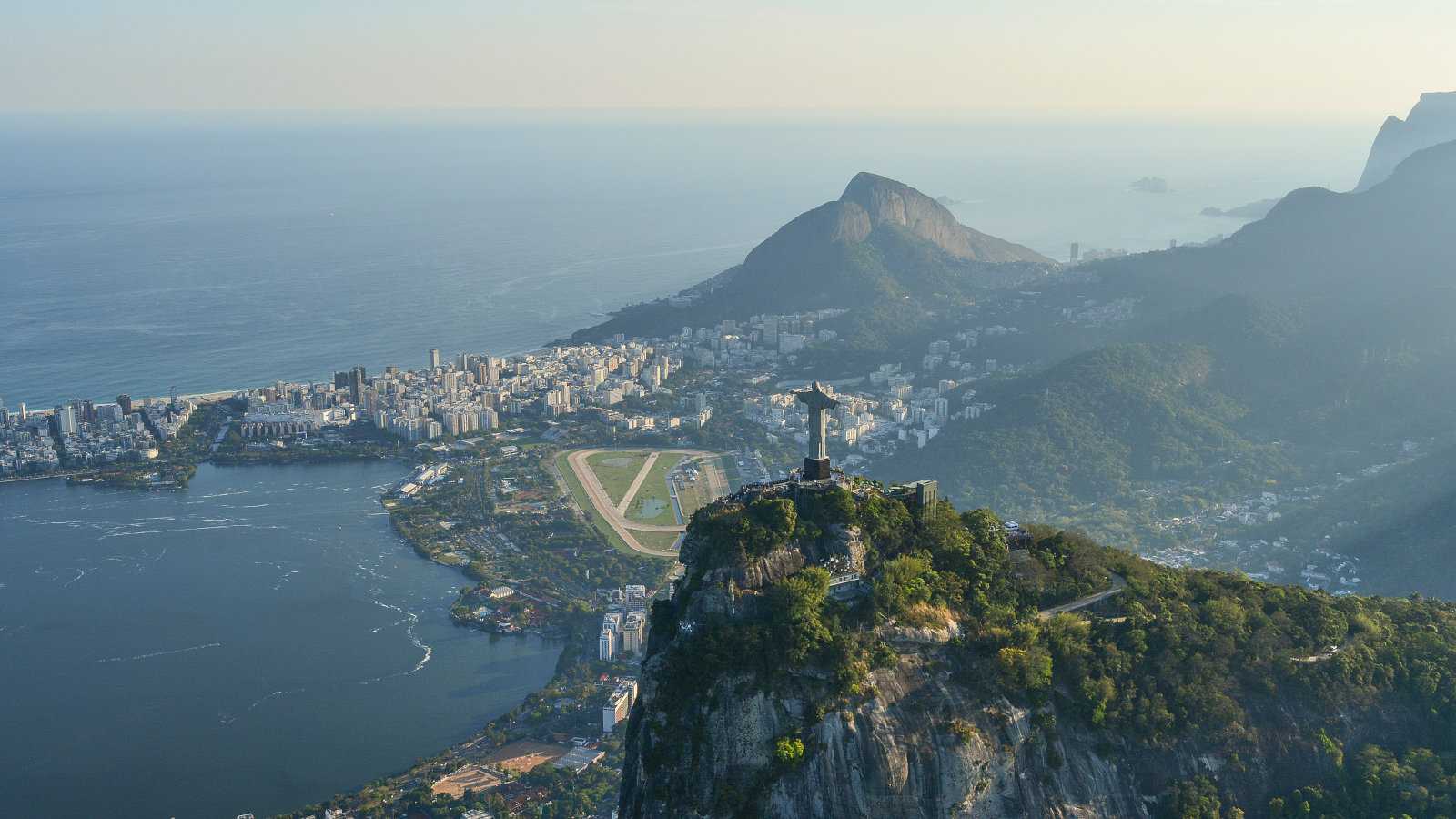 An aerial view of Rio de Janeiro in Brazil with the statue of Christ the Redeemer looking down over the harbor.