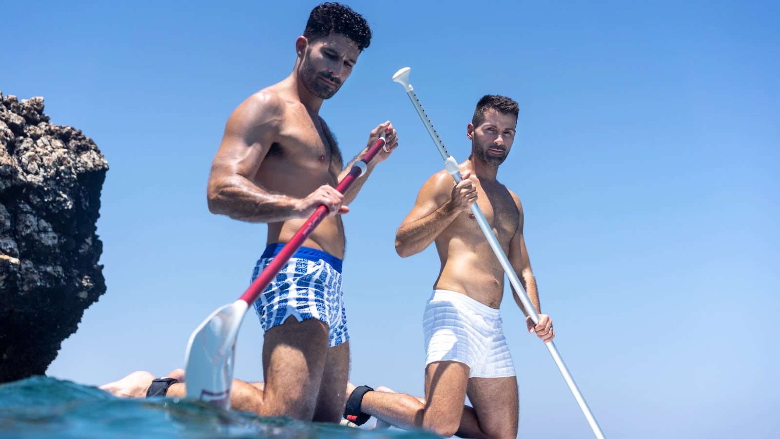 Stef and Seby paddleboarding in their Modus Vivendi swimwear.