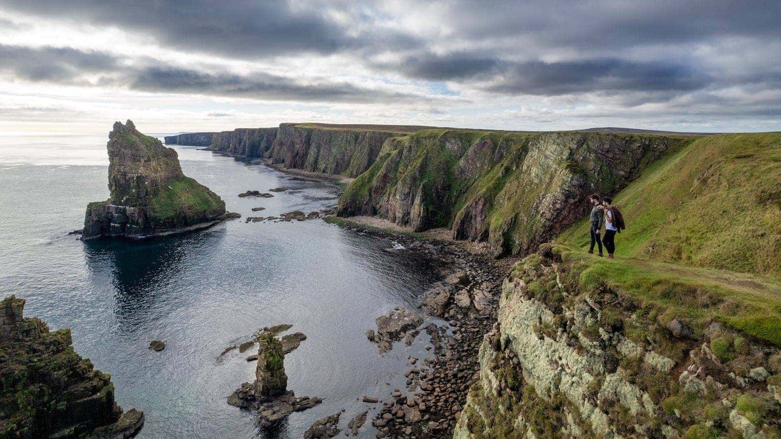Gay couple posing at the Duncansby Stacks in Caithness, Scotland.