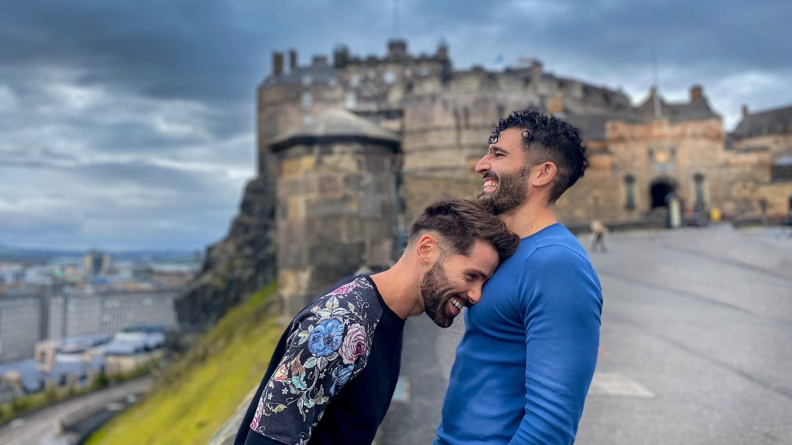 Gay couple laughing together at Edinburgh Castle, Scotland.