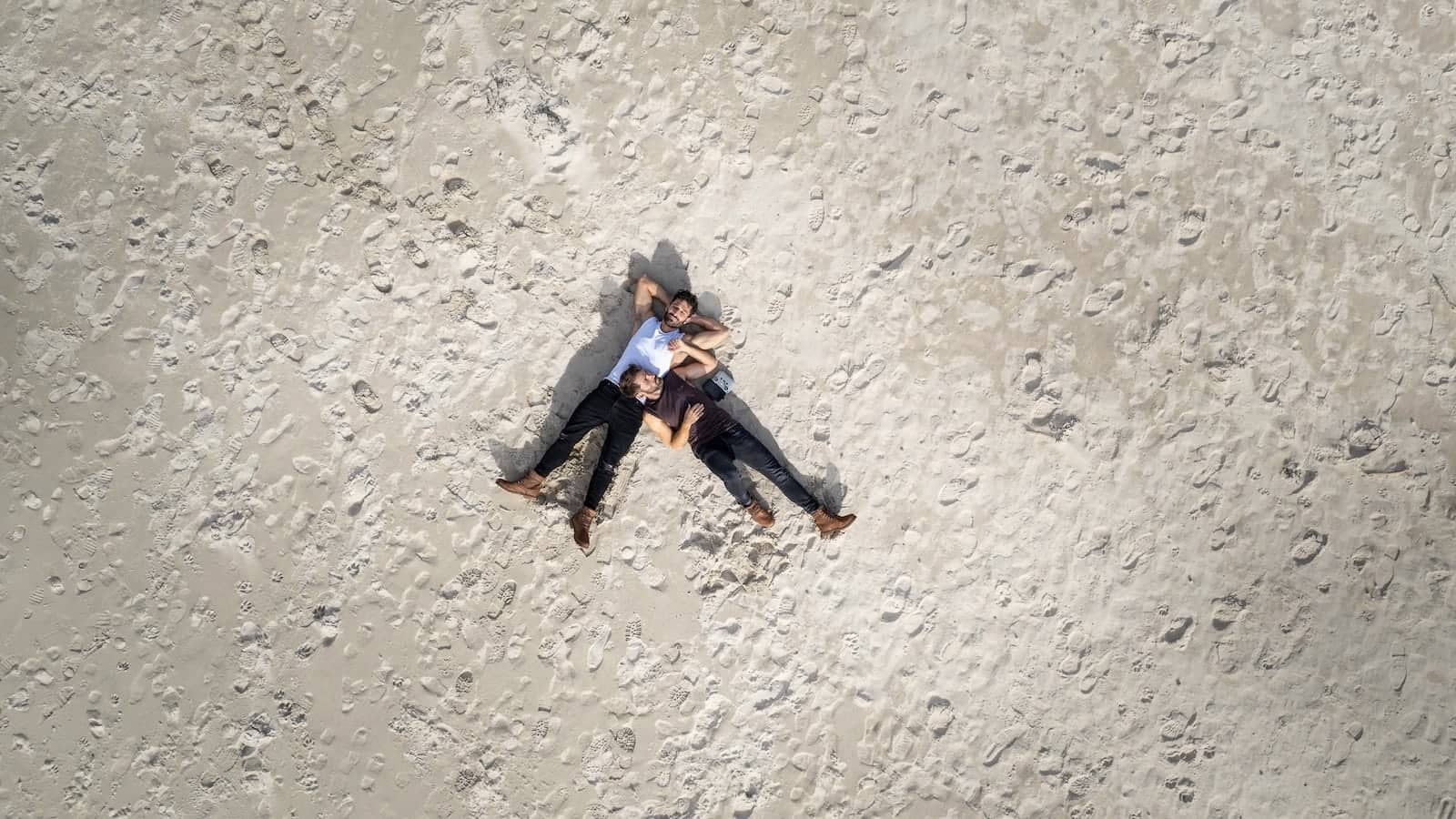 Gay couple relaxing on Machir Bay beach on Isle of Islay in Scotland.