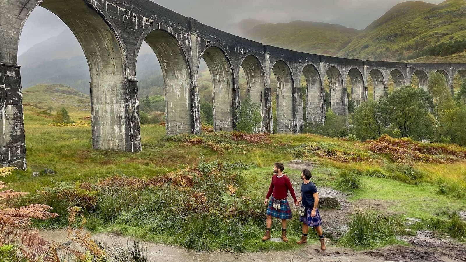 Gay couple in kilts at the Glenfinnan Viaduct, Scotland.