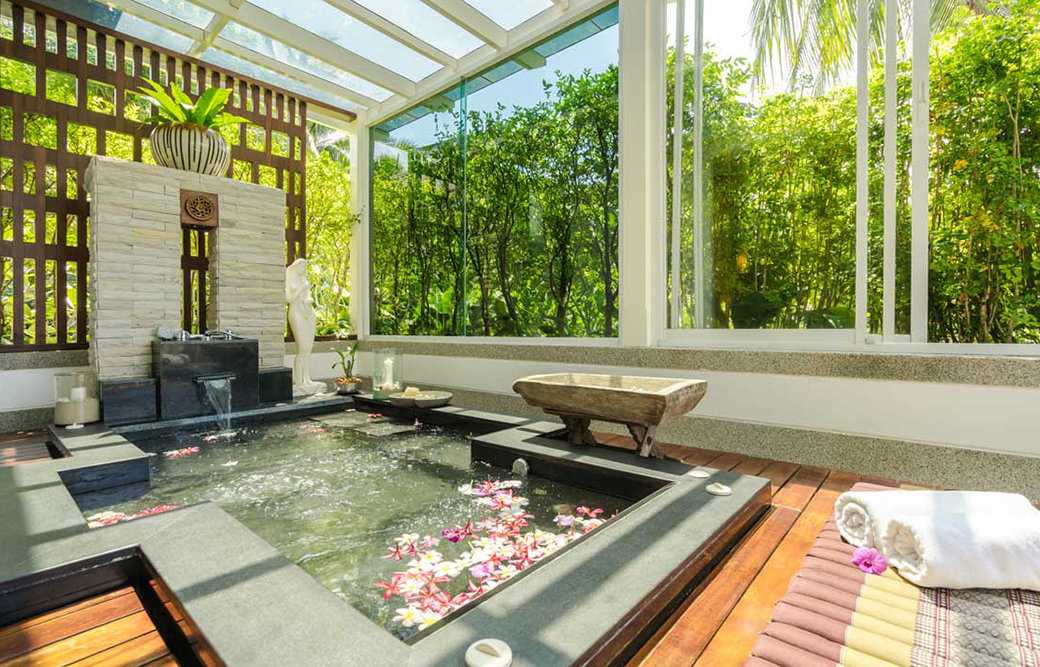 A beautiful Jacuzzi inside a pavilion on a sunny day.