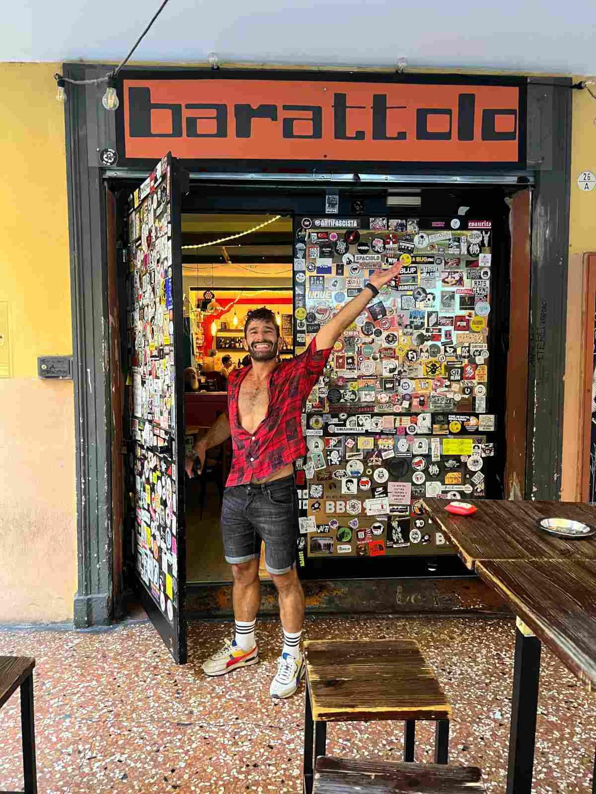Stefan posing joyously in front of the door of the Barattolo gay bar in Bologna, Italy.