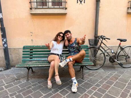 Stefan and his sister sitting on a bench and smiling in the Italian town of Ravenna.