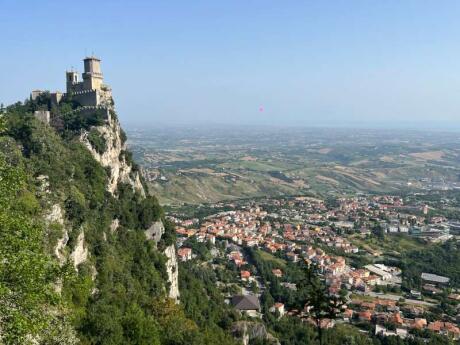 Epic views of a building perched on a cliff looking out over a city on a clear day.