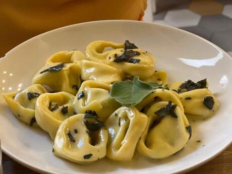 A plate of delicious tortellini on a white plate.